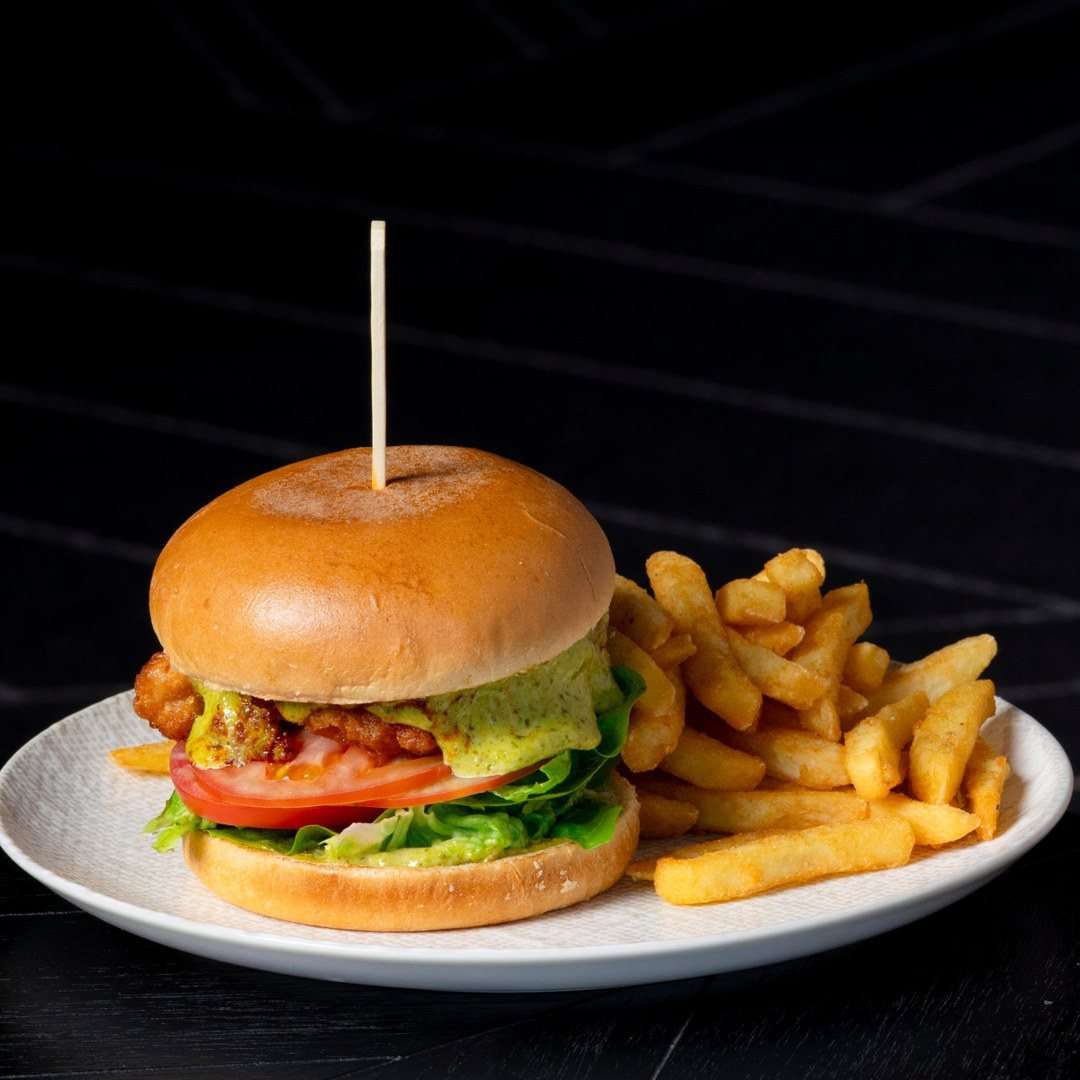 Burger with lettuce, tomato and sauce served with golden chips at Conservatory, Fuller Sports.